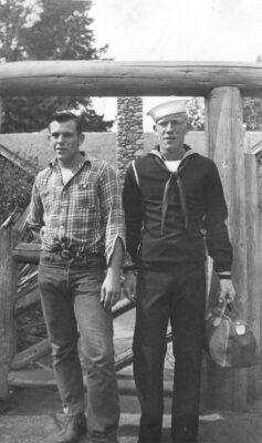 historic photo of two men one in navy blues and the other in a plaid shirt and jeans