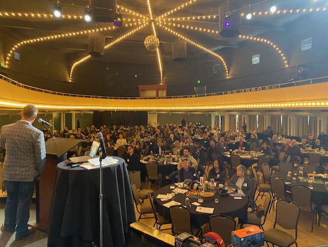 People sitting in an audience listening to a presenter