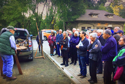 Group listening outdoors to a preservation talk.