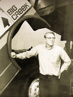 Black and white photo of bud standing next to a truck.