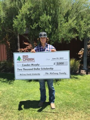 Man with big check, wearing a hat