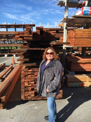 Woman standing in front of a unit of lumber