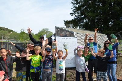 Kids with their hands in the air excited about a donation