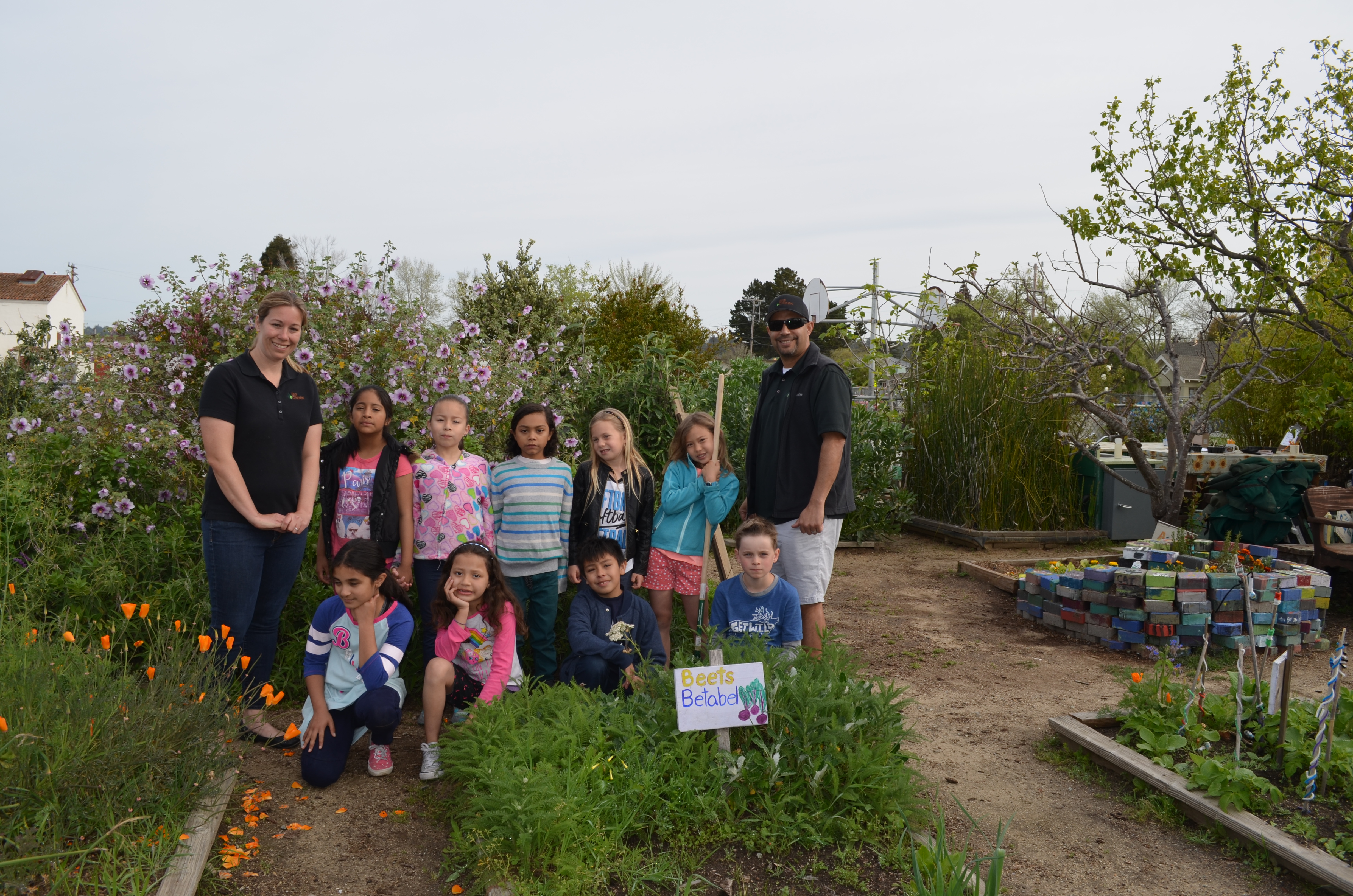 Kids and Adults in a garden with tools