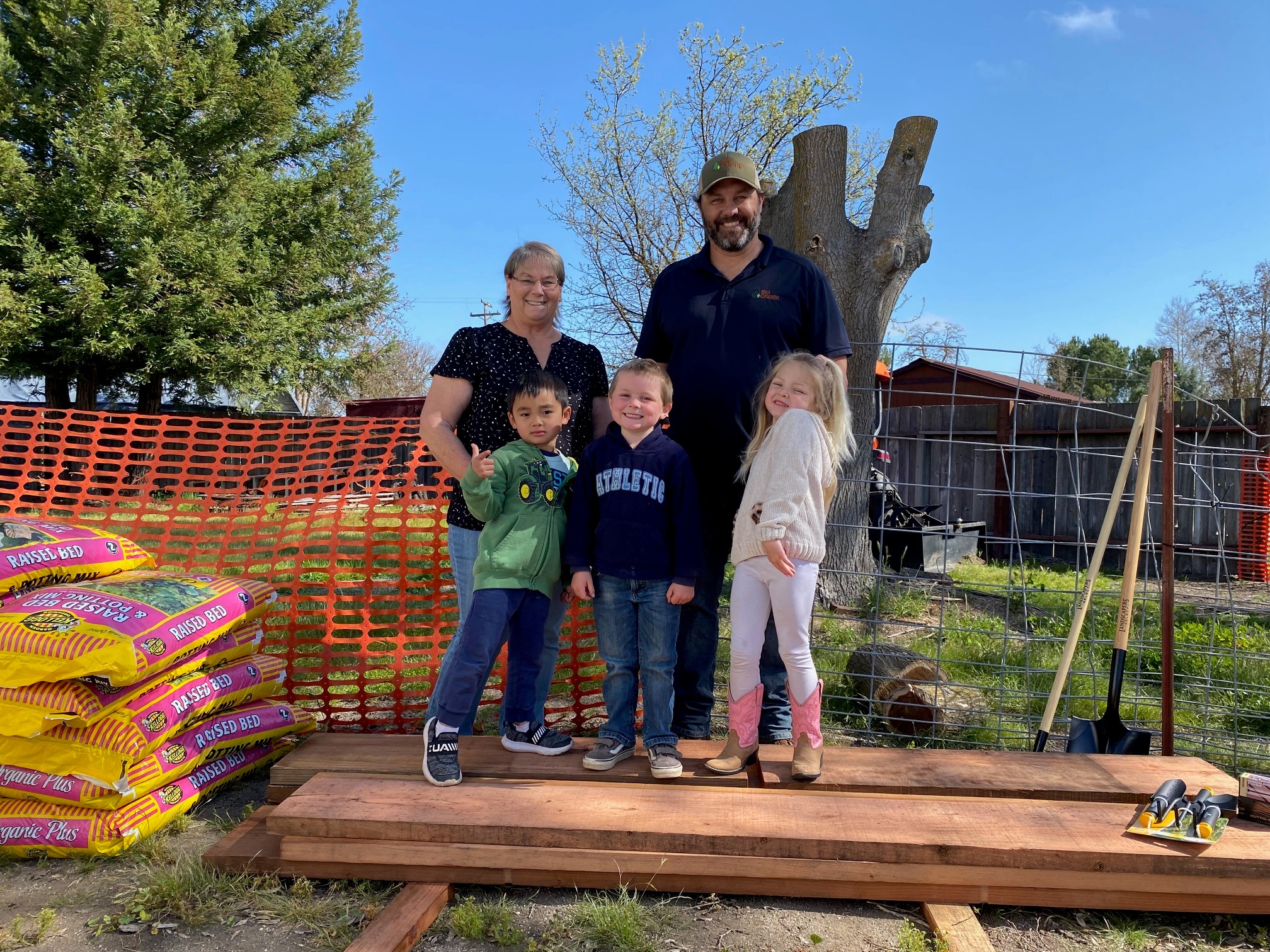 Kids with lumber and their daycare teacher getting materials donated