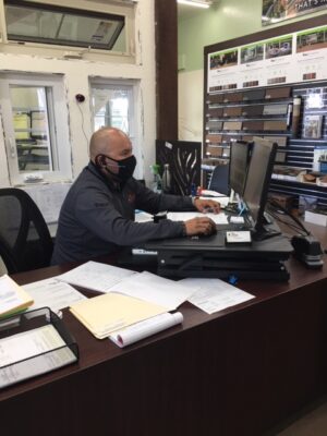 Man on computer at desk with face mask on