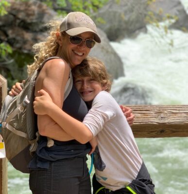 Woman hugging her son in front of rapids