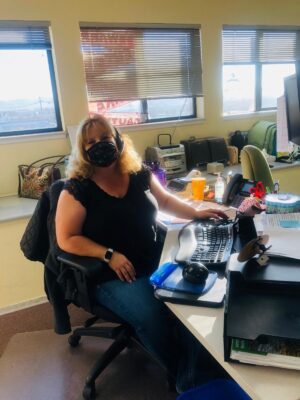 lady sitting at her desk with her mask on