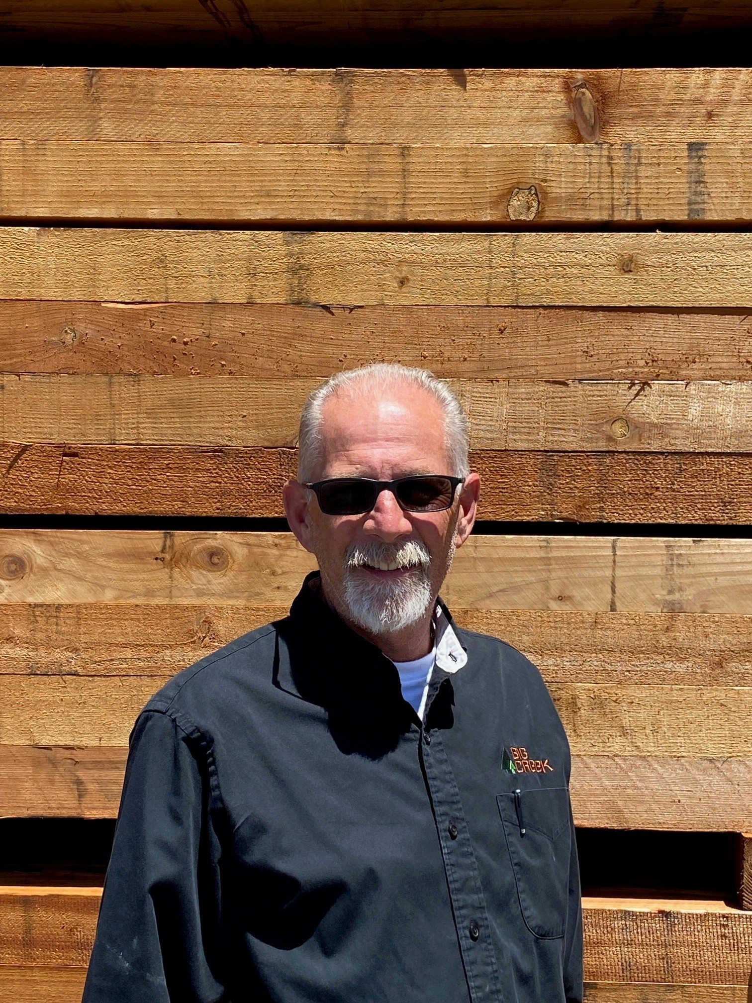 Man standing in front of stacks of lumber