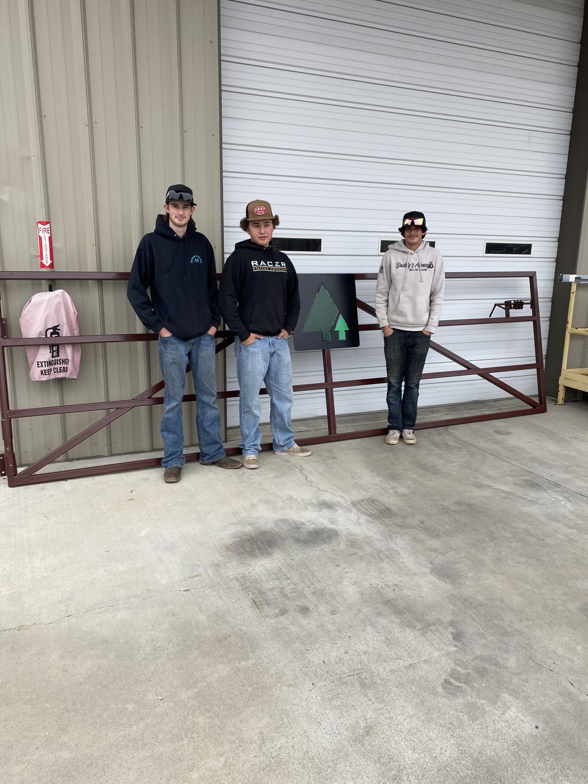 students in front of a gate they built